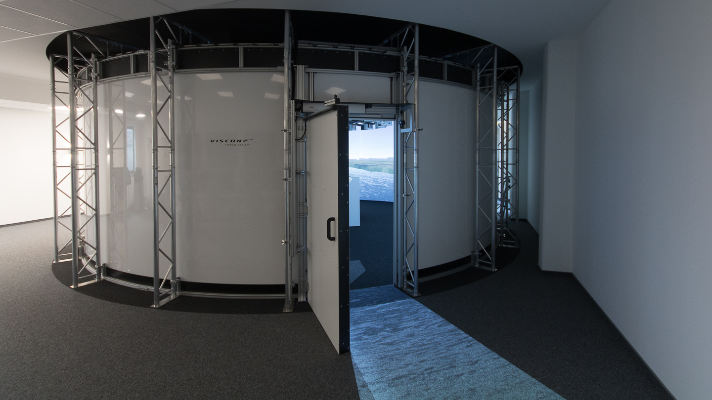 Der Simulator besteht aus einem Projektionssystem, einem Fahrstand und den im Hintergrund arbeitenden Simulationsrechnern.